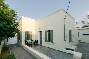 a courtyard of a white house with a table and chairs at Evgenia's House in Ampavris