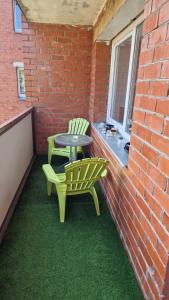 Un patio con una mesa y dos sillas en una pared de ladrillos. en MC apartments, en Rēzekne