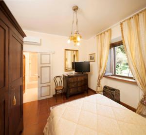 a bedroom with a bed and a tv and a window at Villa Irene in Magione