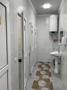 a white bathroom with a sink and a toilet at Irbis Hostel in Karakol