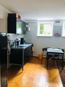 a kitchen with a sink and a table with chairs at Ferienwohnung Lichterfelde Apartment in Berlin +7 photos