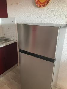 a stainless steel refrigerator in a small kitchen at Corsica studio Face à la mer Moriani plage in San-Nicolao