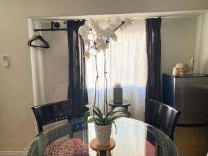 un tavolo di vetro con un vaso di fiori sopra di Pasadena Old Town 2 a Pasadena Altre 2 foto