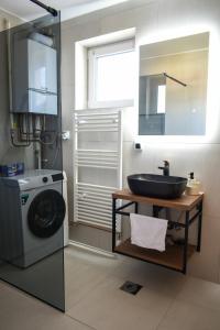 a bathroom with a sink and a washing machine at Lux Apartment - Čakovec city centre in Čakovec