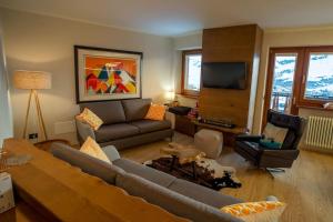 a living room with a couch and a tv at Luxury flat in Cervinia 34 in Breuil-Cervinia