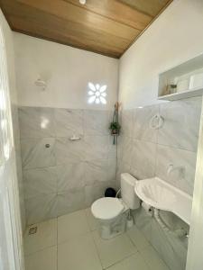 a bathroom with a toilet and a sink and a shower at Villa Careca in Luis Correia +76 photos