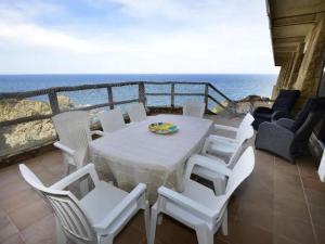 Una mesa blanca y sillas en un balcón con vista al mar. en Apartament CSS 197, en Begur