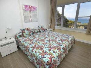 Un dormitorio con una cama con una colcha colorida. en Apartament CSS 197, en Begur 6 fotos más