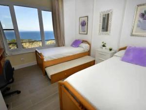Un dormitorio con dos camas con vista al mar. en Apartament CSS 197, en Begur