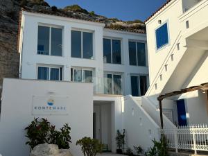 a white building with a sign that reads at Kontemare Seascape in Koumeika