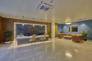 a lobby with a bar with chairs and a couch at Grand Continent Mysore A Sarovar Portico Affiliate Hotel in Mysore