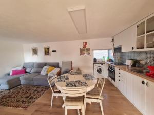 una cucina e un soggiorno con un tavolo e un divano di Sintra Cottage a Sintra