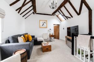 a living room with a couch and a tv at Hideaway Cottage Bewdley with parking near the River Severn in Bewdley
