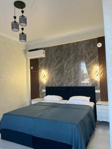 1 dormitorio con 1 cama azul y pared de mármol en Zam-Zam Hotel Turkestan, en Türkistan
