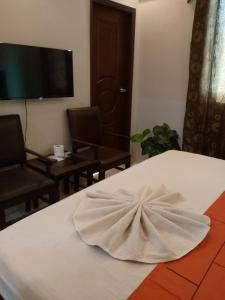 a room with a white bed with a bow on it at GOHO Rooms Badar in Karachi +64 photos