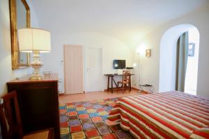 1 dormitorio con cama, mesa y espejo en La Casa di Carla, en Ravello