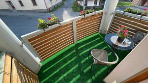 a balcony with a table and a fence with a table and chair at Apartmán Smrk in Vrbno pod Pradědem
