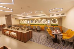 a restaurant with tables and chairs and mirrors at Mannat Residency By iO Hotels Near Golden Temple in Amritsar
