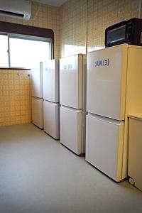 a row of refrigerators are lined up in a room at 白浜レジデンス 1日1組限定 ファミリー向け 炭火焼イタリアンディナー付き in Minamiboso