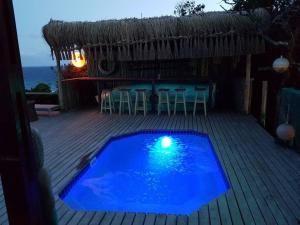 a swimming pool on a deck with a table and chairs at Mar Azul 14 in Ponta Malangane