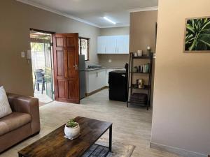 ein Wohnzimmer mit Sofa und Tisch in der Unterkunft Forest Drive Cottage in Kloof