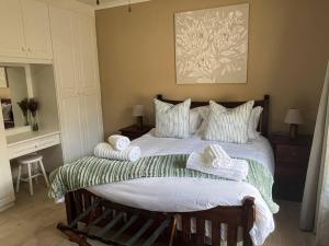 ein Schlafzimmer mit einem großen Bett mit Handtüchern darauf in der Unterkunft Forest Drive Cottage in Kloof