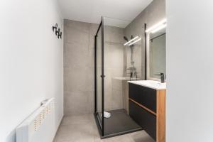 une salle de bain avec douche et lavabo dans l'établissement Marlie s Home - comfort stadsapp met zonnig terras, à Nieuport 10 autres photos