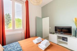 a bedroom with a bed with two white towels at Le Petit Monet - City center near train station in Vernon