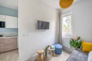 a living room with a couch and a kitchen at Le Petit Monet - City center near train station in Vernon