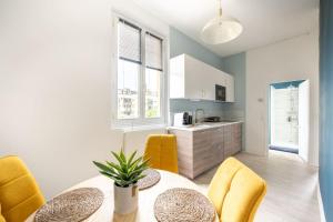 a kitchen and dining room with a table and chairs at Le Petit Monet - City center near train station in Vernon