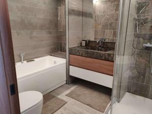 ein Badezimmer mit Badewanne, Toilette und Waschbecken in der Unterkunft Appartamento elegante in centro Q434 in Breuil-Cervinia + 24 Fotos