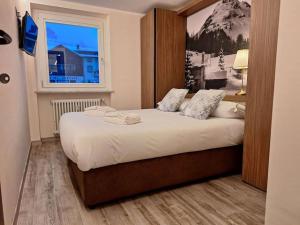 ein Schlafzimmer mit einem großen Bett mit Fenster in der Unterkunft Appartamento elegante in centro Q434 in Breuil-Cervinia