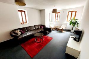 un soggiorno con divano in pelle e tappeto rosso di zentrale Ferienwohnung - direkt am See und in Schlossnähe a Schwerin