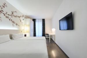 a hotel room with a bed and a flat screen tv at Catalonia La Boquería in Barcelona