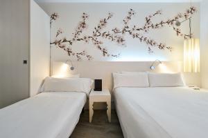 two beds sitting next to each other in a room at Catalonia La Boquería in Barcelona +16 photos