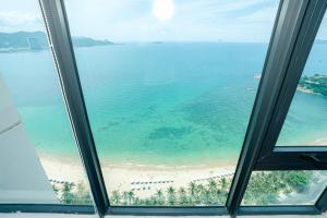 a view of a beach from an office window at Sunrise from bed Apartment - NhaTrang Beach in Nha Trang