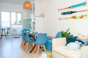 a living room with blue chairs and a table at Sunrise from bed Apartment - NhaTrang Beach in Nha Trang