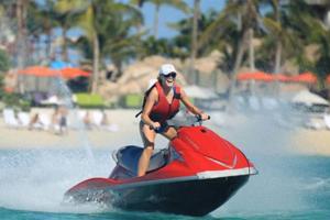 a woman riding a jet ski on the water at Baga Beach Palms in Baga