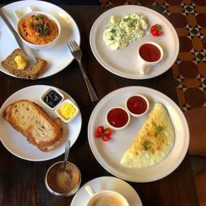 a table with plates of breakfast food on it at Baga Beach Palms in Baga