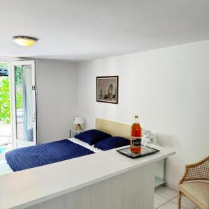 a bedroom with a bed and a table with a bottle at Studio Cosy en pleine nature in Saint-Jouan-des-Guérets