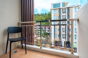 - Balcón con silla y vistas a un edificio en Nice to meat you Rooms, en Patong Beach