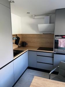 a kitchen with white cabinets and wooden counters at Tosmares Apartment in Liepāja +9 photos