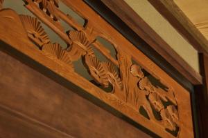 a wooden door with a carving on it at UNO RETREAT Kyoto Gluten Free & Vegan Hotel in Kyoto
