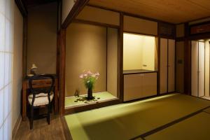 a room with a chair and a vase with flowers in it at UNO RETREAT Kyoto Gluten Free & Vegan Hotel in Kyoto