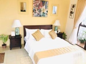 a bedroom with a white bed and two night stands with lamps at Modern Studio Gem - Two Balconies with Ocean & Mountain Views in Cebu City