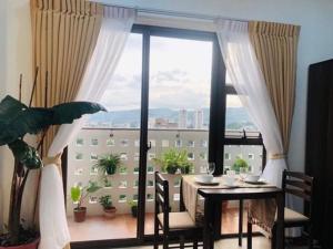 a dining room with a table and a large window at Modern Studio Gem - Two Balconies with Ocean & Mountain Views in Cebu City