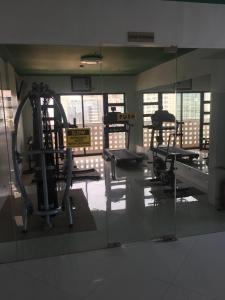 a gym with several tread machines and a mirror at Modern Studio Gem - Two Balconies with Ocean & Mountain Views in Cebu City