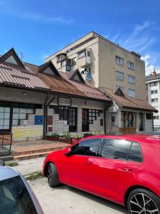 a red car parked in front of a building at Apartman LITTLEHOME Travnik in Travnik