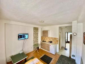 an empty living room with a tv on the wall at Apartman LITTLEHOME Travnik in Travnik