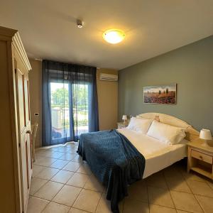 a bedroom with a bed and a large window at Le Residenze di Santa Costanza - Le Dimore in San Vincenzo